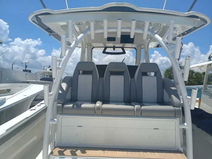 41-083 Yacht Photos Pics 2023 Regulator 41 boat interior with cushioned seating and rod holders under a clear sky.