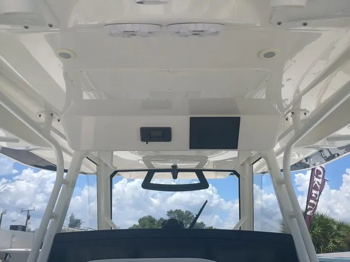 41-083 Yacht Photos Pics 2023 Regulator 41 boat interior with modern helm and clear sky background.