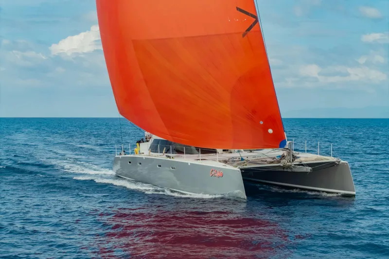 Gizmo Yacht Photos Pics Sailing catamaran Morrelli & Melvin 65 custom, 2012, with vibrant orange sail on open sea.