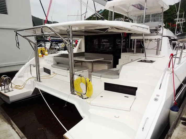 Meow Or Never Yacht Photos Pics 2020 Leopard 45 catamaran docked, featuring spacious deck and seating area.