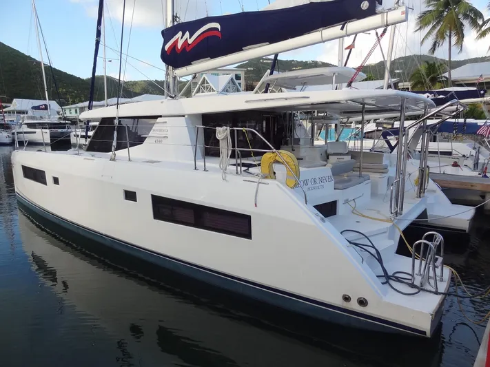 Meow Or Never Yacht Photos Pics 2020 Leopard 45 catamaran docked at marina with scenic background.