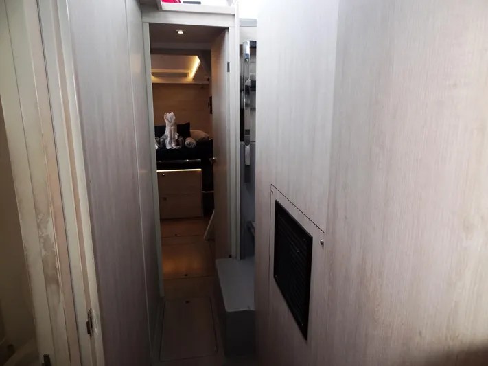 Meow Or Never Yacht Photos Pics Narrow hallway inside 2020 Leopard 45 yacht, leading to a well-lit cabin.