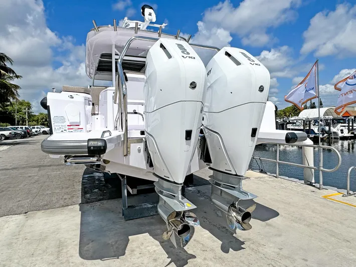  Yacht Photos Pics 2025 Axopar 37 Sun Top with dual outboard engines docked under a blue sky.