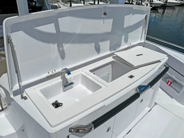  Yacht Photos Pics 2025 Axopar 37 Sun Top boat kitchen area with sink and storage compartments.