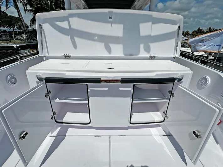  Yacht Photos Pics 2025 Axopar 37 Sun Top boat with open storage compartments and sleek design.