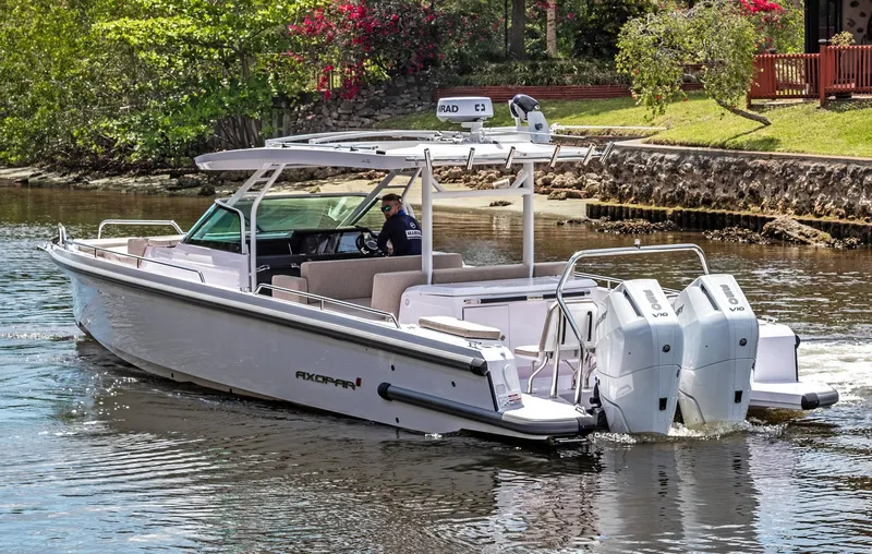  Yacht Photos Pics 2025 Axopar 37 Sun Top boat cruising on a scenic waterway.