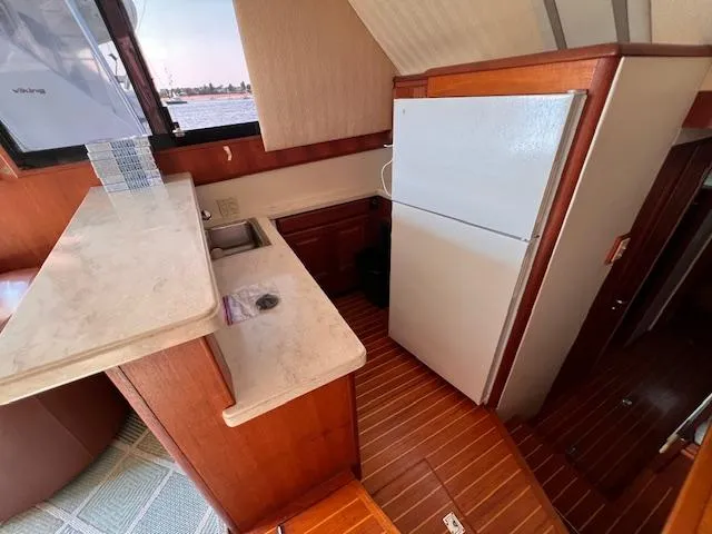  Yacht Photos Pics 1993 Viking 45 Convertible yacht kitchen with wood flooring and white countertops.