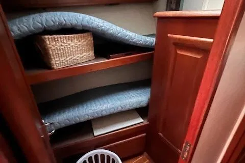  Yacht Photos Pics Wooden storage cabinet with shelves, cushions, and a wicker basket on a 1993 Viking 45 Convertible.