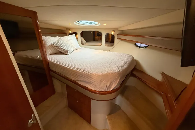 Houligan's Haven Yacht Photos Pics Luxurious cabin interior of 2004 Cruisers 370 Express yacht with cozy bed and elegant wood finish.