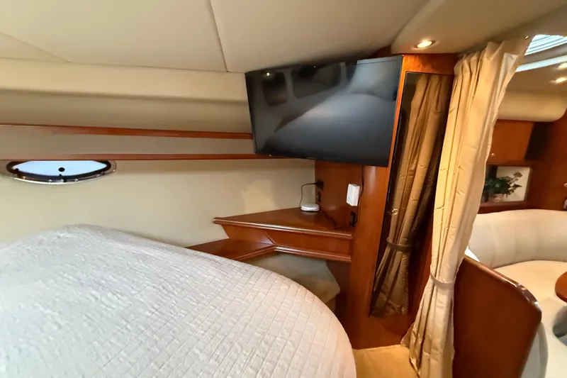 Houligan's Haven Yacht Photos Pics Interior of 2004 Cruisers 370 Express yacht with TV, bed, and elegant wood finish.