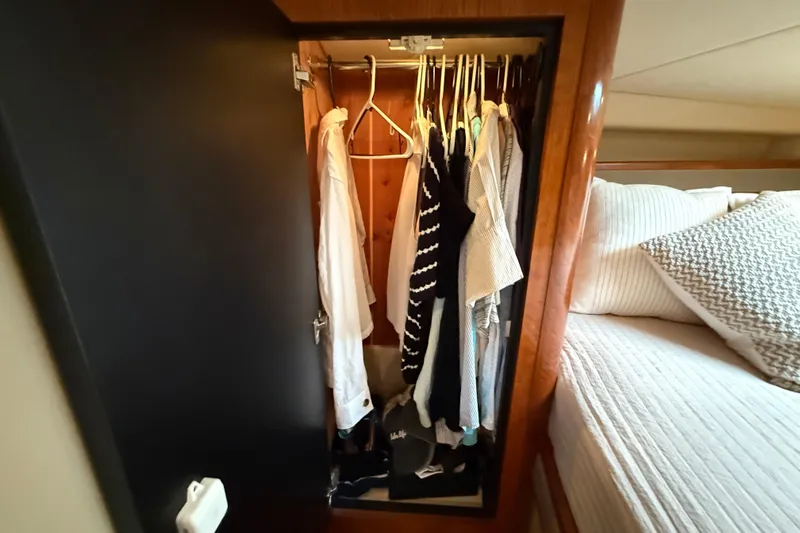 Houligan's Haven Yacht Photos Pics Closet with clothes inside a 2004 Cruisers 370 Express yacht bedroom.