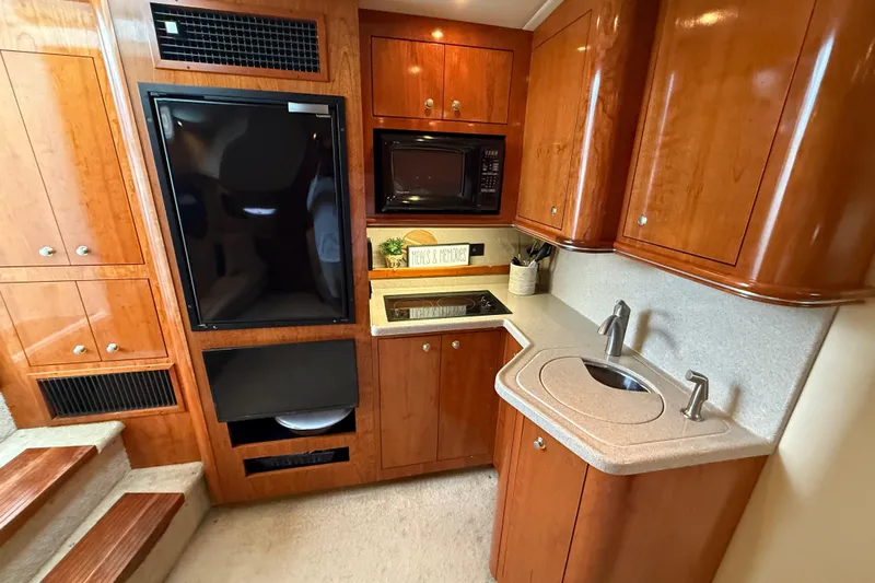 Houligan's Haven Yacht Photos Pics 2004 Cruisers 370 Express yacht kitchen with wood cabinetry, sink, and appliances.