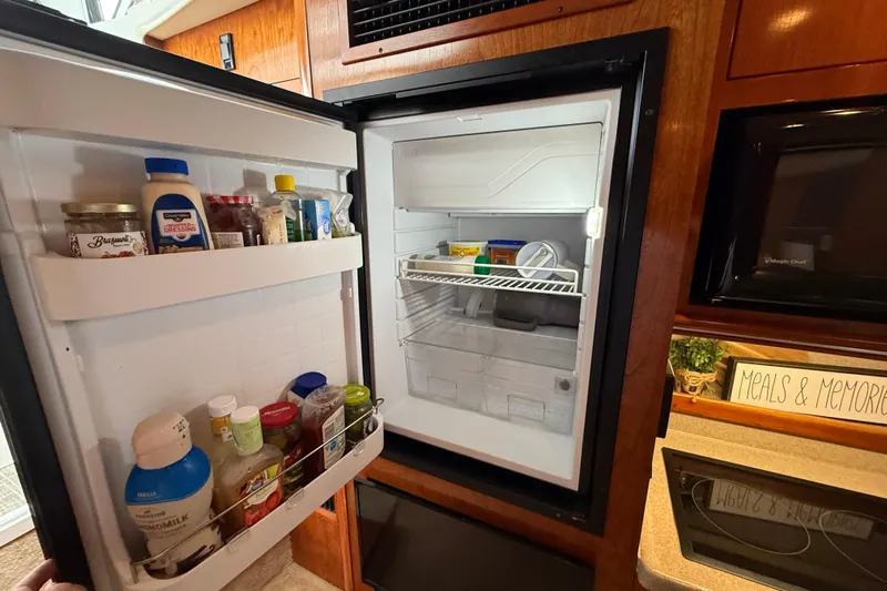 Houligan's Haven Yacht Photos Pics Open refrigerator in 2004 Cruisers 370 Express yacht kitchen, stocked with condiments and beverages.