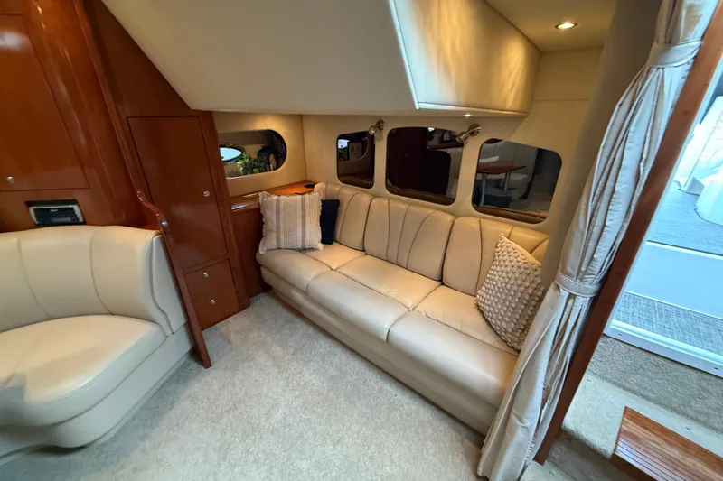 Houligan's Haven Yacht Photos Pics 2004 Cruisers 370 Express yacht interior with beige leather seating and wooden cabinetry.