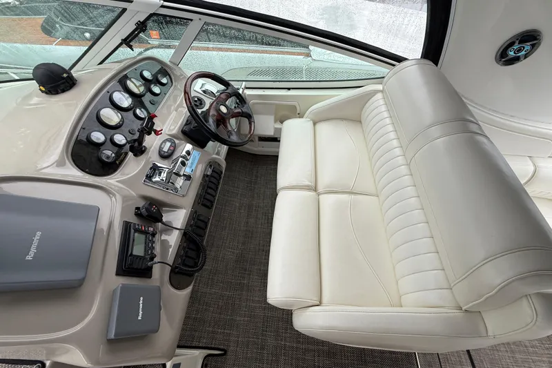 Houligan's Haven Yacht Photos Pics 2004 Cruisers 370 Express helm with white leather seating and modern controls.