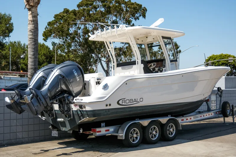 Elixir Yacht Photos Pics 2023 Robalo R302 Center Console boat on trailer, featuring dual outboard engines.