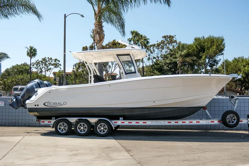 Elixir Yacht Photos Pics 2023 Robalo R302 Center Console boat on trailer, parked outdoors.