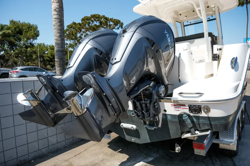 Elixir Yacht Photos Pics 2023 Robalo R302 Center Console with dual outboard engines, parked outdoors.