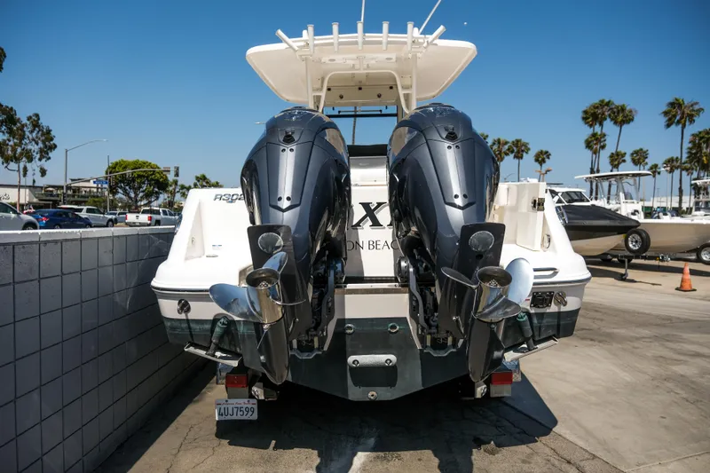 Elixir Yacht Photos Pics 2023 Robalo R302 Center Console boat with dual outboard engines, docked at a marina.