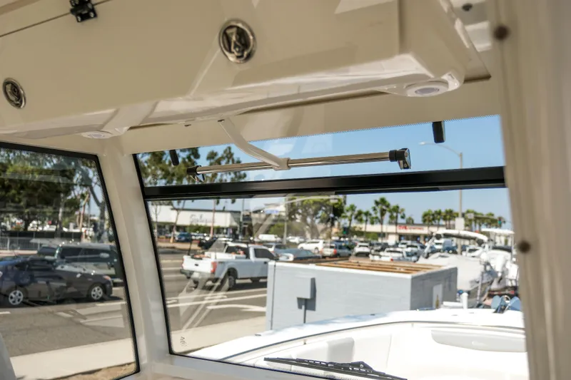 Elixir Yacht Photos Pics 2023 Robalo R302 Center Console boat interior view with open window, showcasing outdoor scenery.