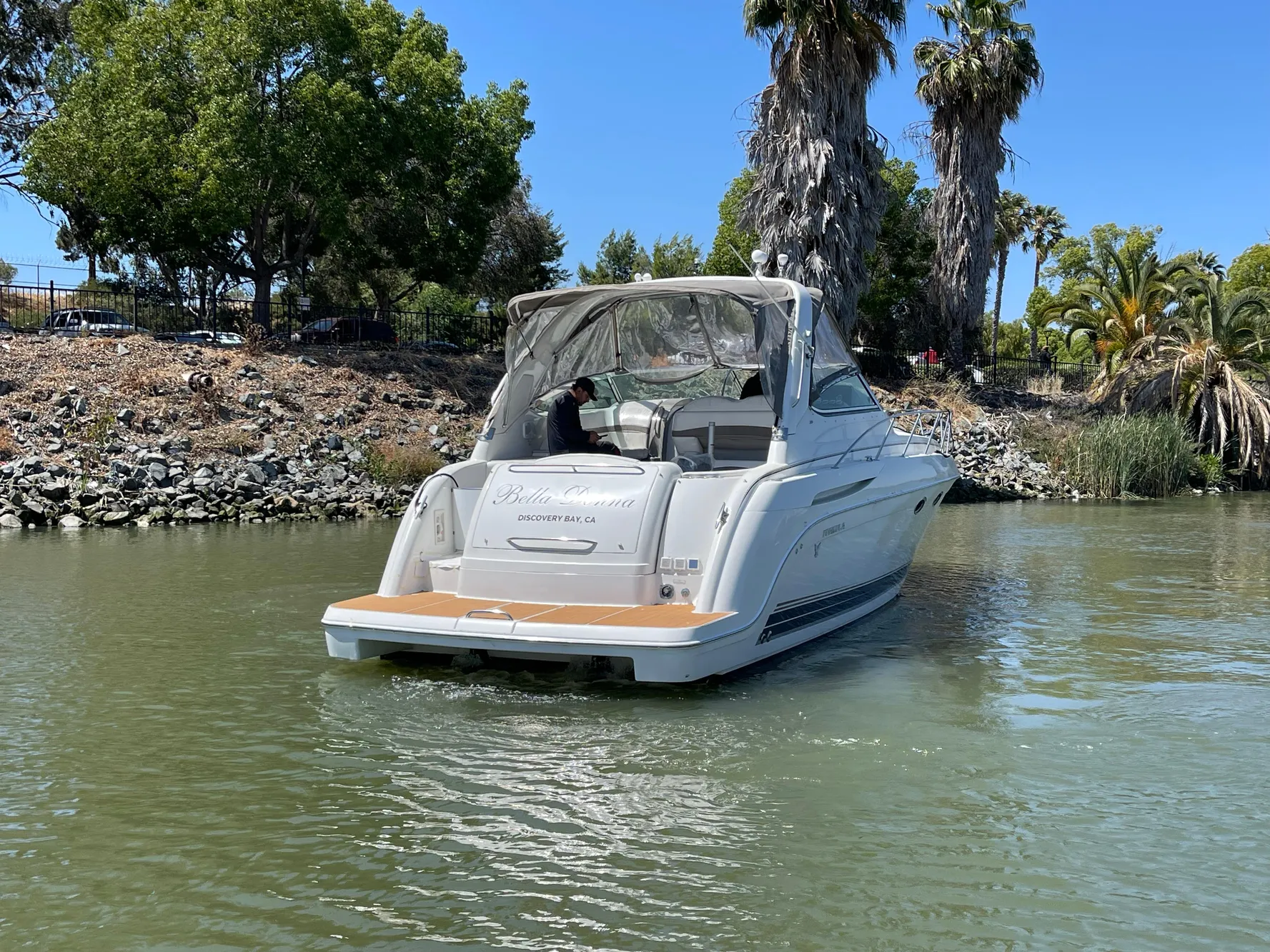 2003 Formula 37 PC yacht cruising on a calm river with lush greenery.
