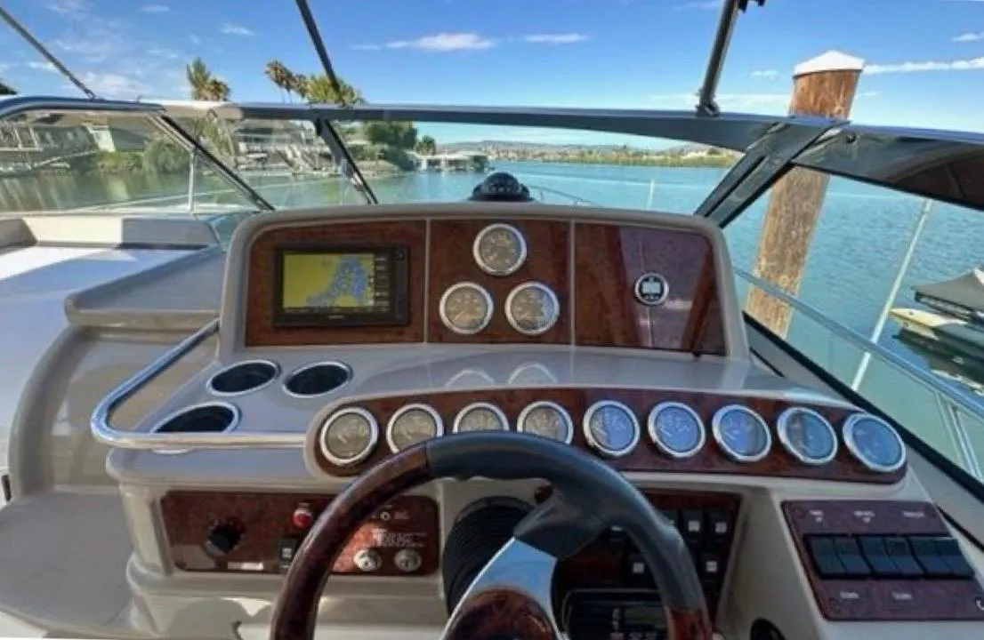 2003 Formula 37 PC yacht dashboard with gauges and navigation system, overlooking serene waters.