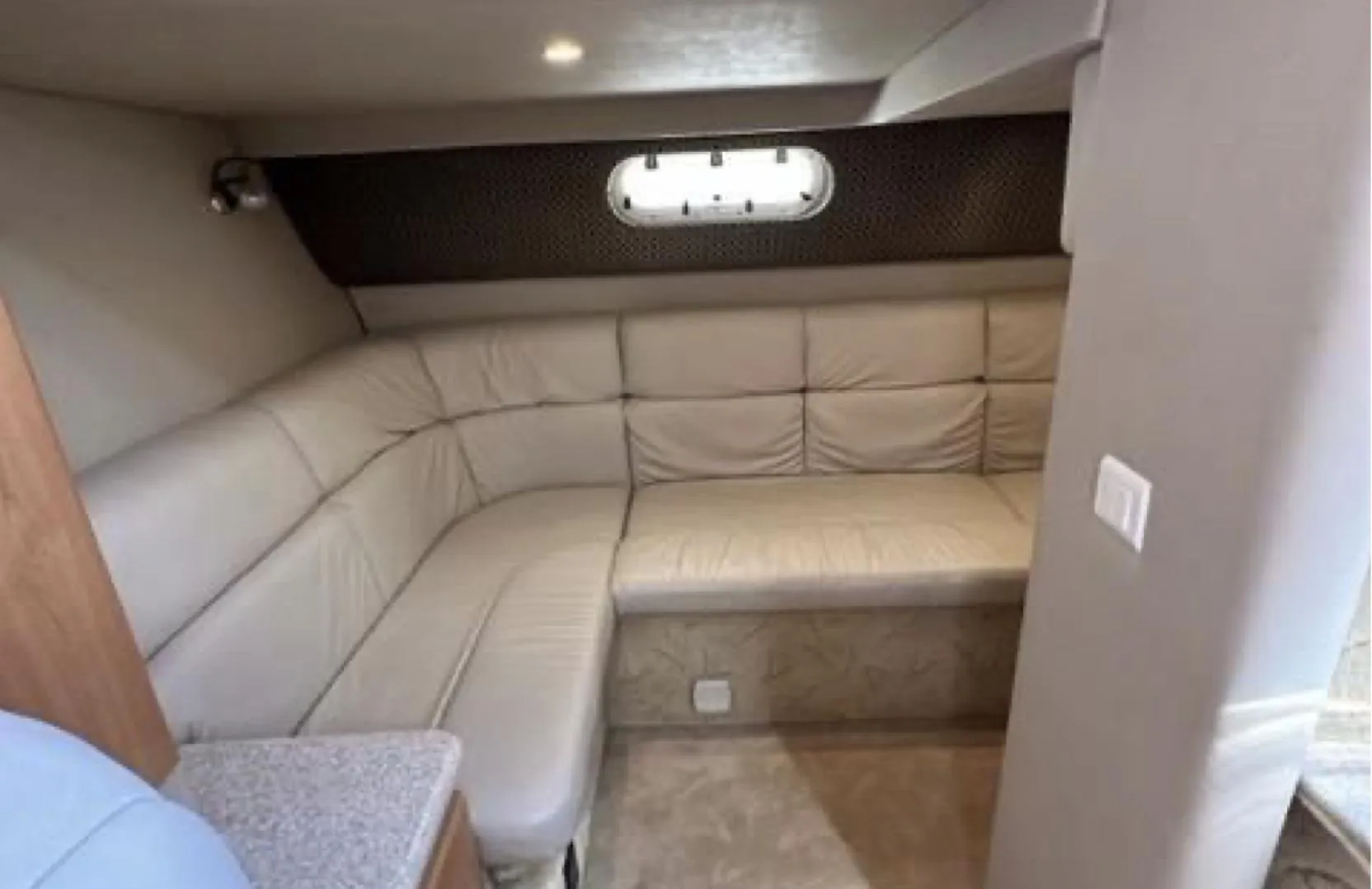 2003 Formula 37 PC yacht interior with beige leather seating and porthole window.