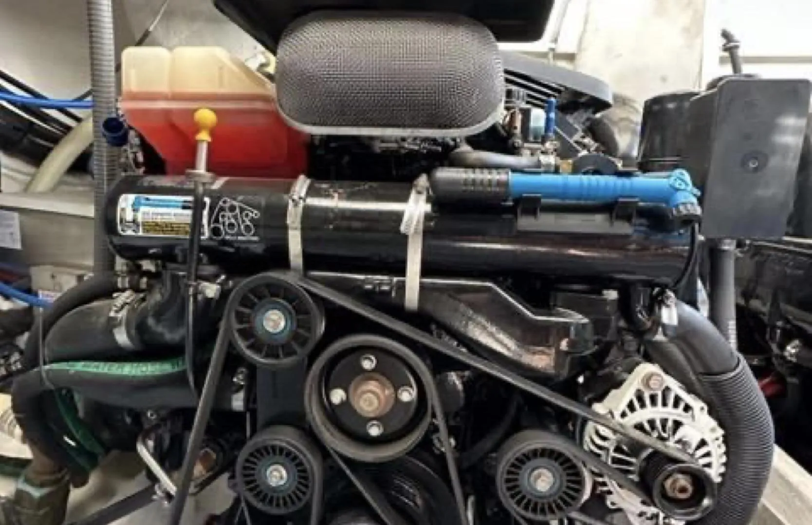 Engine of a 2003 Formula 37 PC boat, showcasing belts and components.