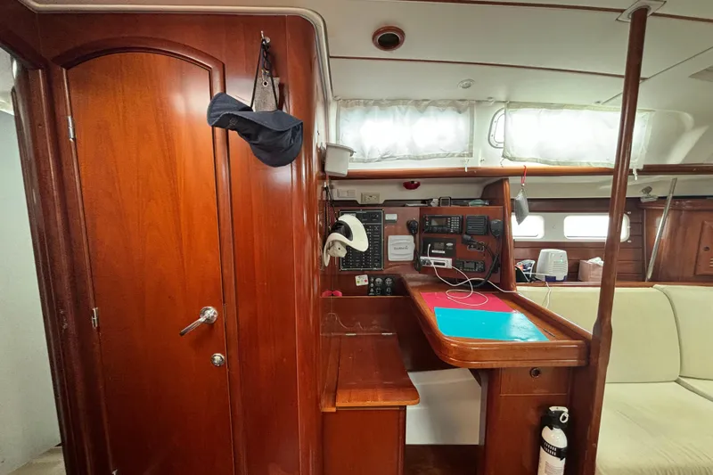 Table 4 Two Yacht Photos Pics Interior of 2004 Beneteau Oceanis 423 sailboat with navigation station and wooden cabinetry.