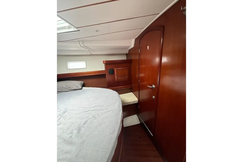 Table 4 Two Yacht Photos Pics Interior cabin of 2004 Beneteau Oceanis 423 yacht with wooden finish and cozy bed.