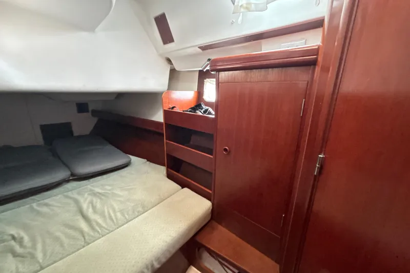 Table 4 Two Yacht Photos Pics Cozy cabin interior of 2004 Beneteau Oceanis 423 sailboat with wooden furnishings.