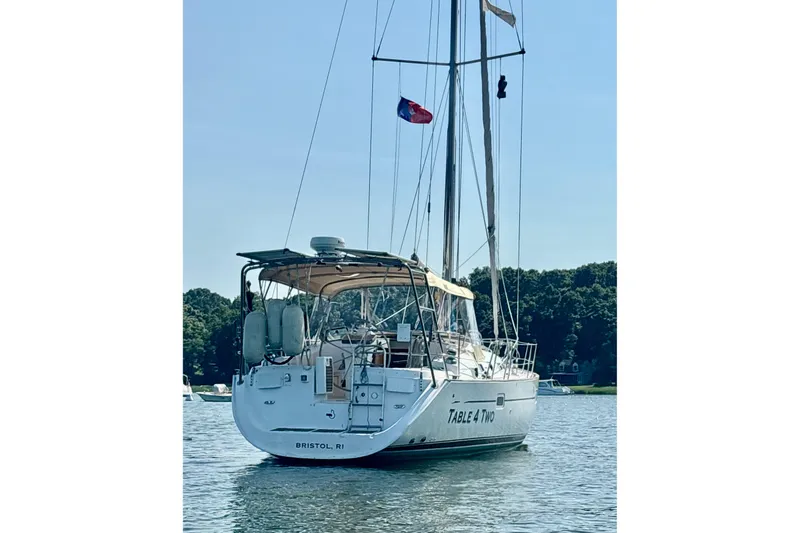 Table 4 Two Yacht Photos Pics 2004 Beneteau Oceanis 423 sailboat anchored on calm water, rear view.
