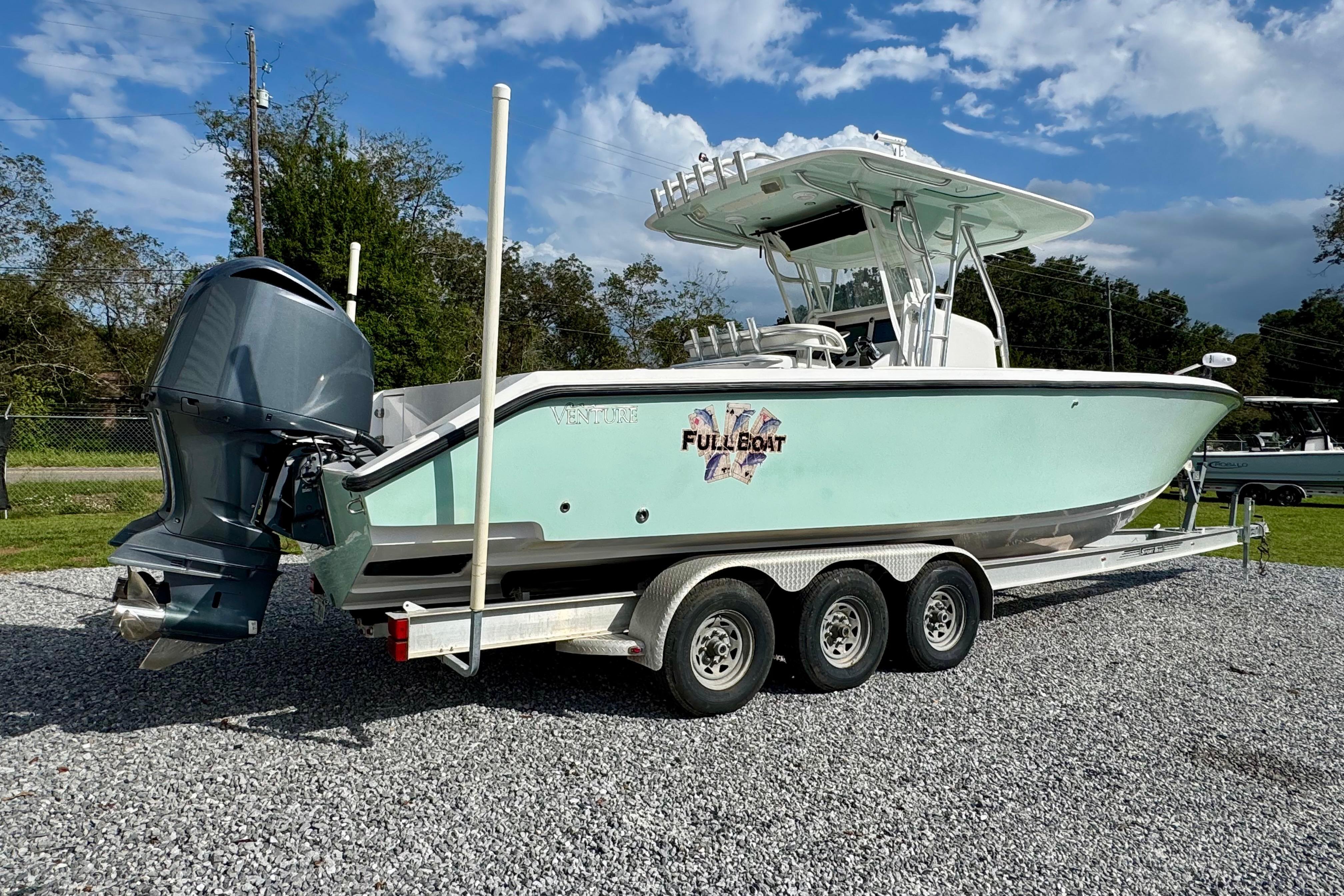 2010 Venture 34 Tournament boat on trailer, featuring outboard motor and sleek design.