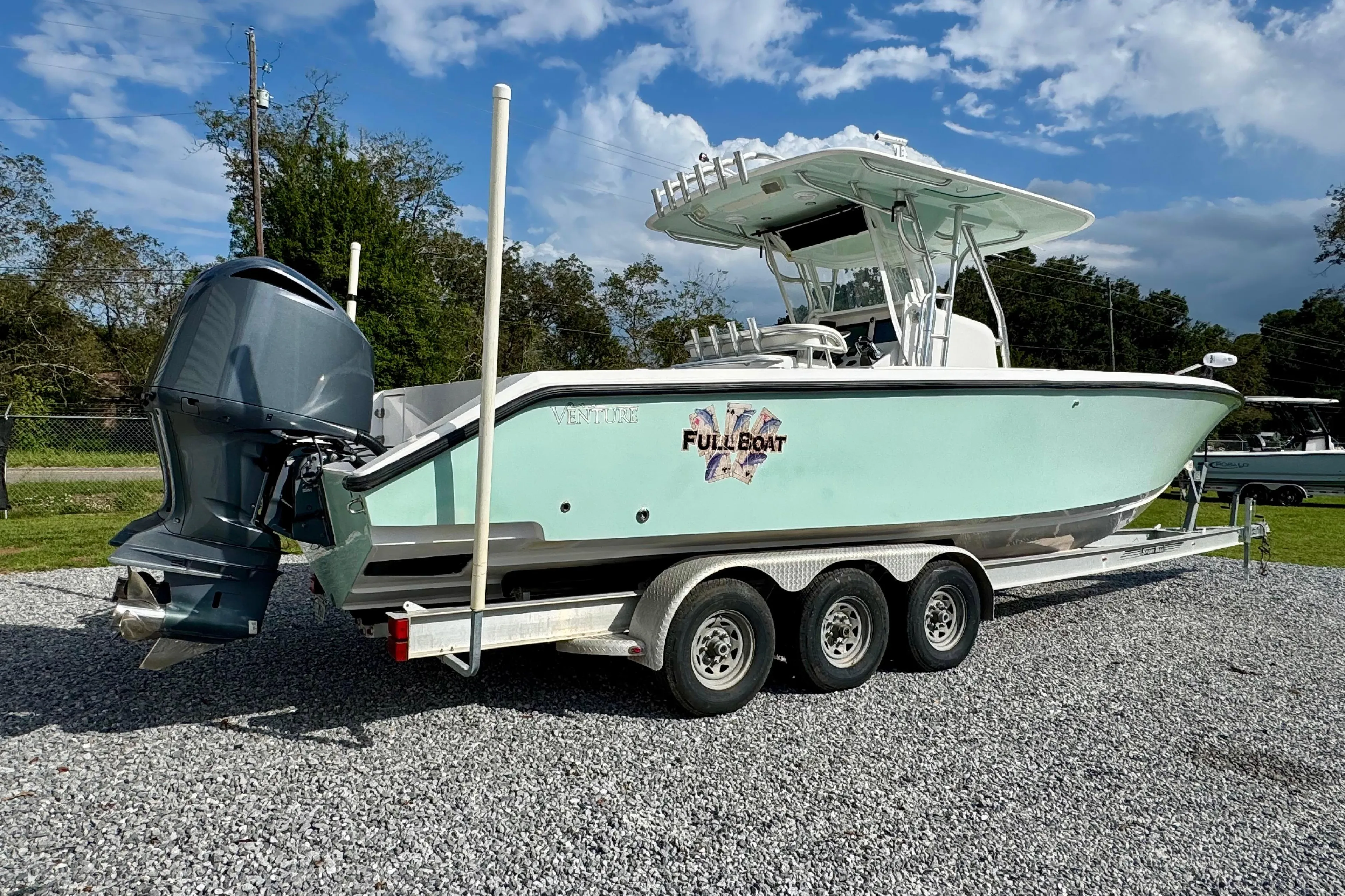2010 Venture 34 Tournament boat on trailer, featuring outboard motor and sleek design.