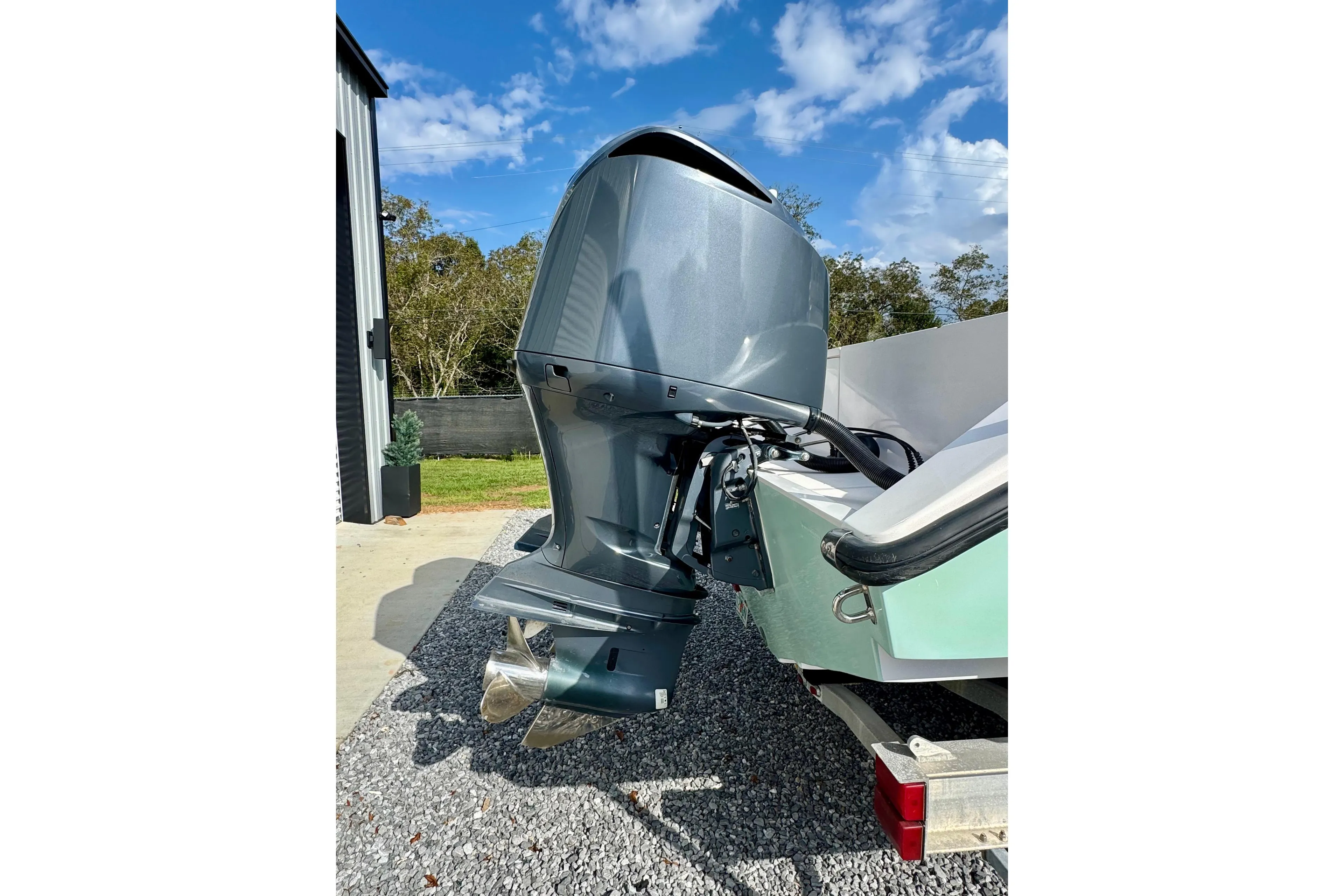 2010 Venture 34 Tournament boat engine, parked outdoors on gravel driveway.