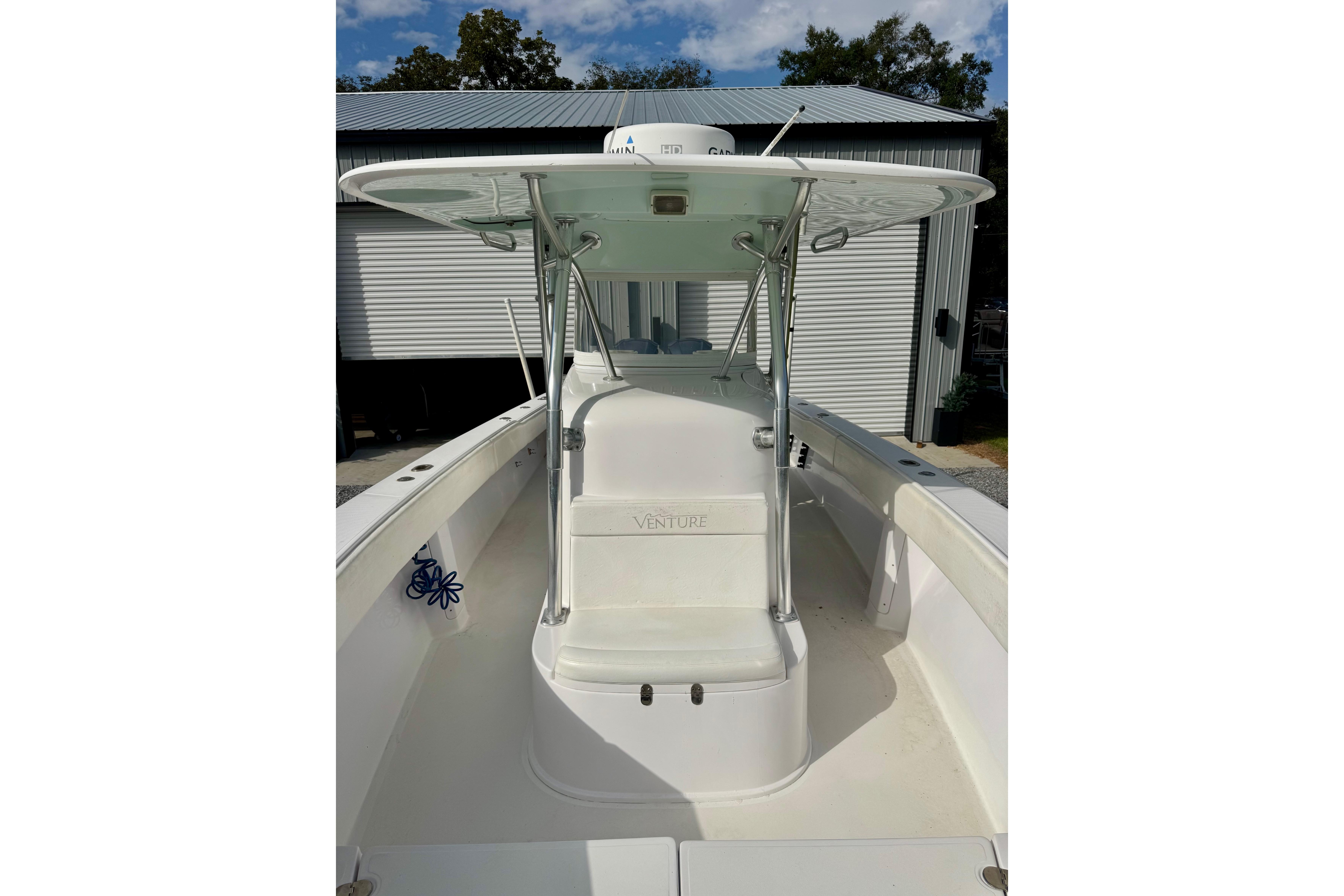 2010 Venture 34 Tournament boat, featuring a sleek white deck and T-top under a blue sky.
