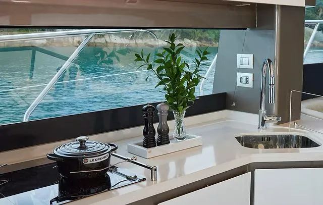  Yacht Photos Pics Modern yacht kitchen interior with sleek design, featuring a Le Creuset pot and scenic ocean view.