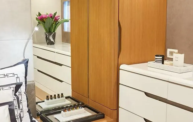  Yacht Photos Pics Modern bedroom with sleek white dressers, wooden wardrobe, and decorative flowers. Schaefer 660, 2025.