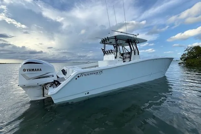  Yacht Photos Pics 2019 Freeman 34 boat with Yamaha engine on calm water under cloudy sky.