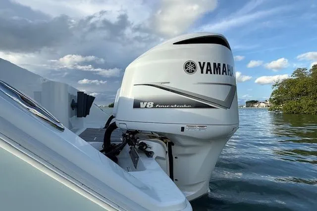  Yacht Photos Pics Yamaha V8 outboard motor on a 2019 Freeman 34 boat, set against a scenic water backdrop.
