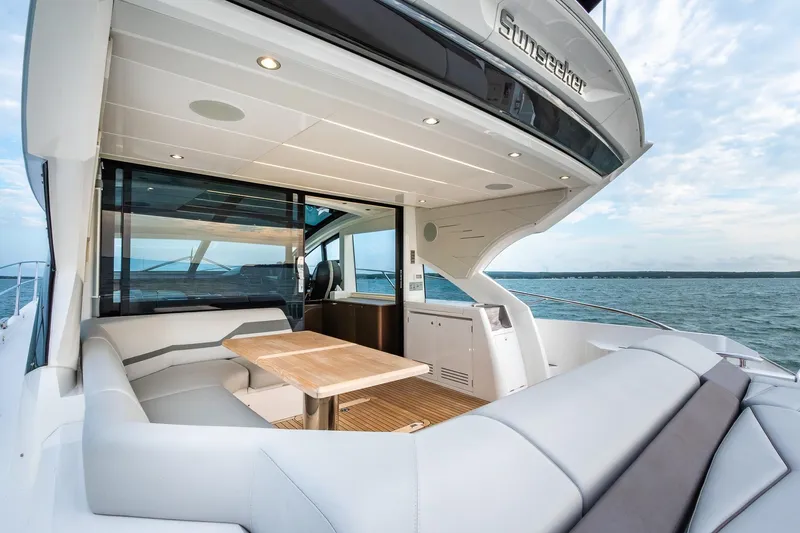 Andielaine IV Yacht Photos Pics Luxurious 2021 Sunseeker 60 Evo yacht with elegant outdoor seating and ocean view.