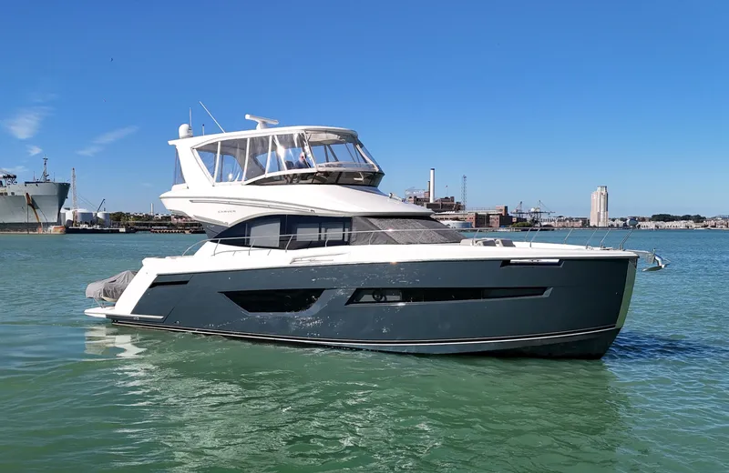 Play Craft Yacht Photos Pics 2018 Carver C52 Flybridge yacht on calm water with cityscape background.
