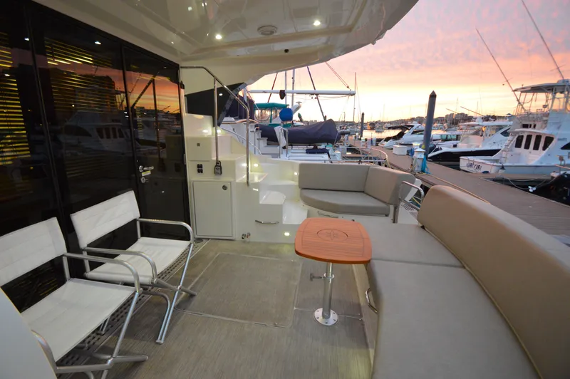 Play Craft Yacht Photos Pics 2018 Carver C52 Flybridge yacht deck at sunset, featuring seating and a wooden table.