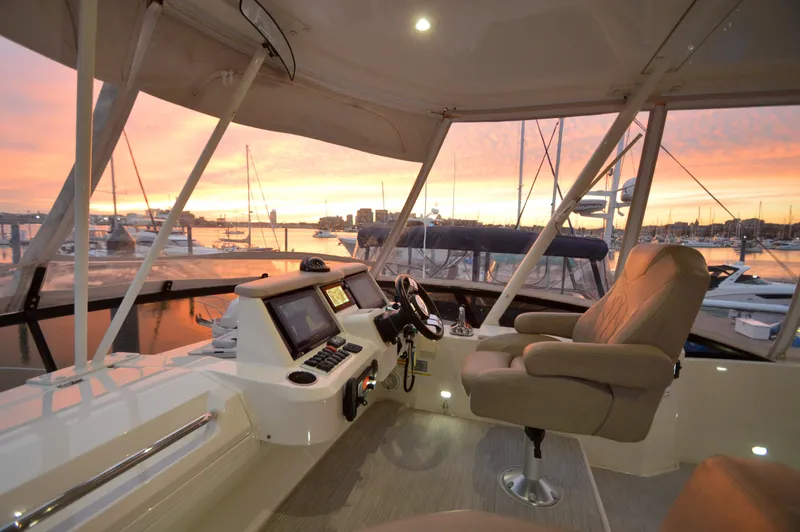 Play Craft Yacht Photos Pics Flybridge of 2018 Carver C52 yacht at sunset, featuring luxurious seating and navigation controls.