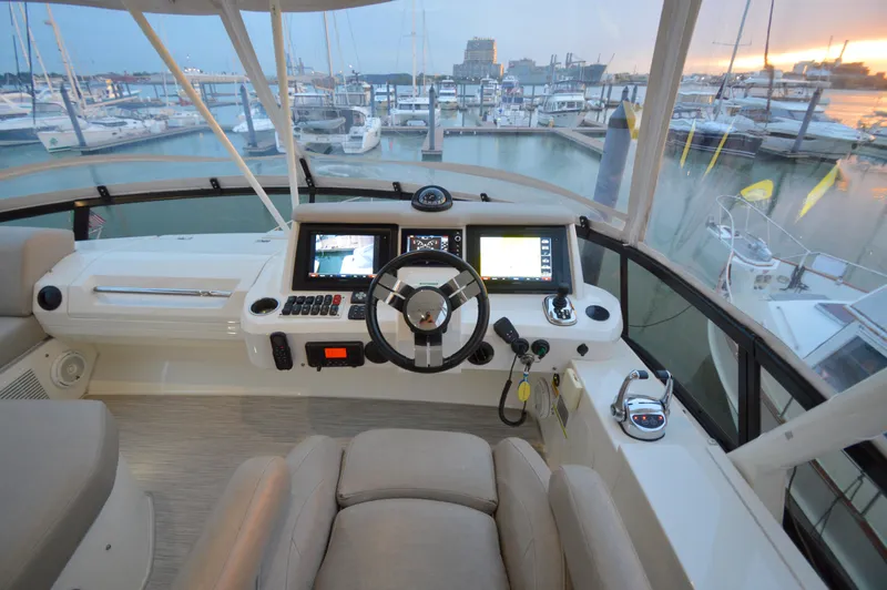 Play Craft Yacht Photos Pics Flybridge helm of 2018 Carver C52 yacht with marina view at sunset.