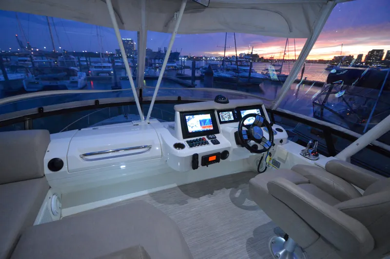 Play Craft Yacht Photos Pics 2018 Carver C52 Flybridge helm with modern controls at sunset marina.