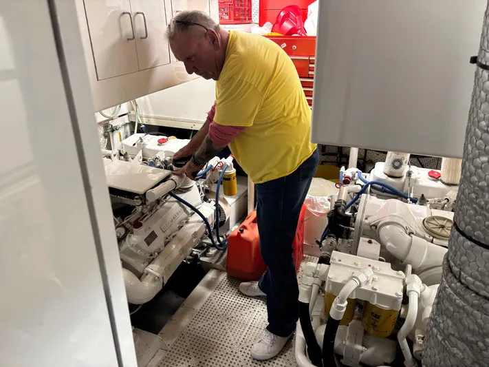  Yacht Photos Pics Man working in engine room of 1987 DeFever 53 POC yacht.