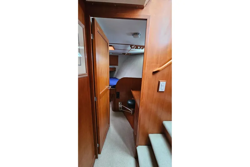  Yacht Photos Pics 1987 DeFever 53 POC yacht interior with wooden paneling and carpeted stairs.
