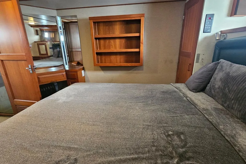  Yacht Photos Pics Interior of 1987 DeFever 53 POC yacht bedroom with wooden shelves and cozy bedding.