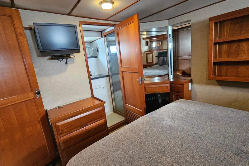  Yacht Photos Pics 1987 DeFever 53 POC yacht interior with wood cabinetry, TV, and cozy bedroom.